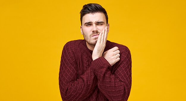 young guy having toothache